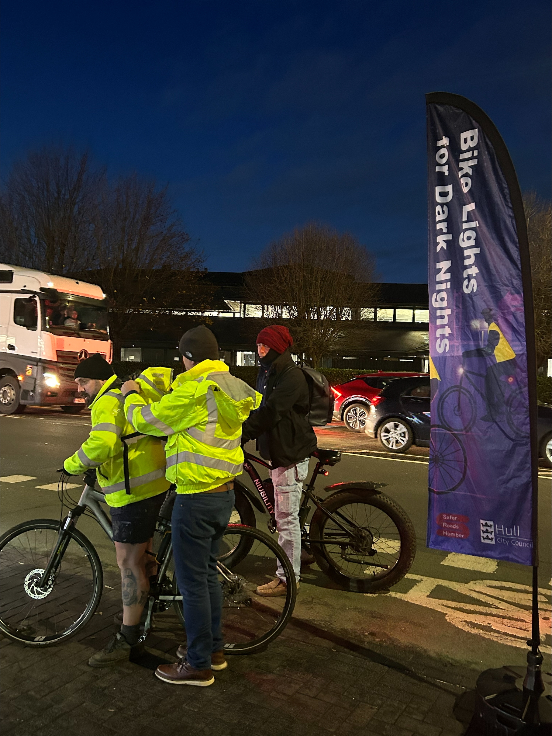 Hull City Council staff fitting bike lights and hi-vis to cyclists on Spring Bank