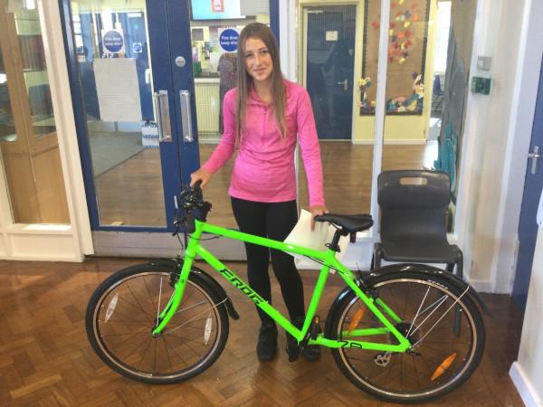 A girl holding a green bike